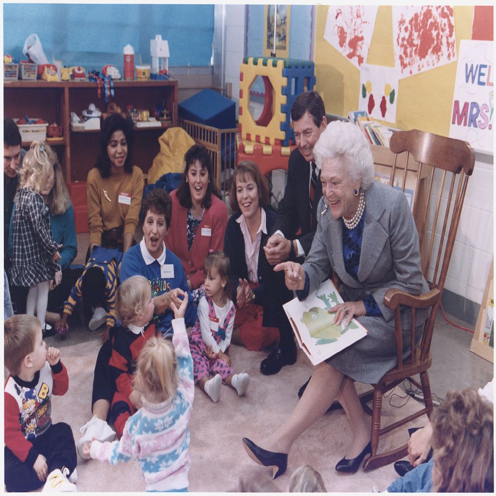 Mrs. Bush and Missouri Governor John Ashcroft attend a "Parents as Teachers" parent/child group at the Ferguson-Florissant School District in Florissant, Missouri where Mrs. Bush reads "Brown Bear Brown Bear" to the children